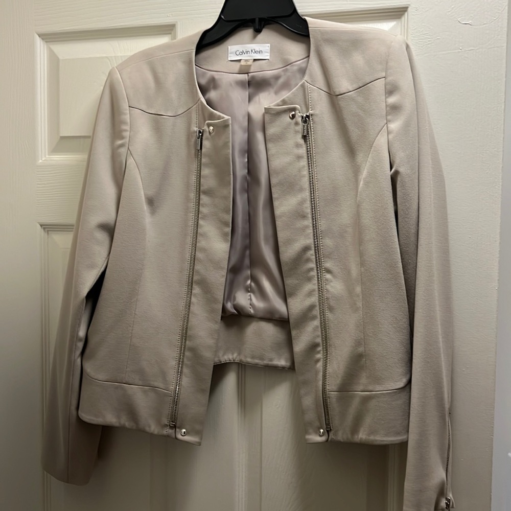 Tan Calvin Klein blazer with silver zipper.